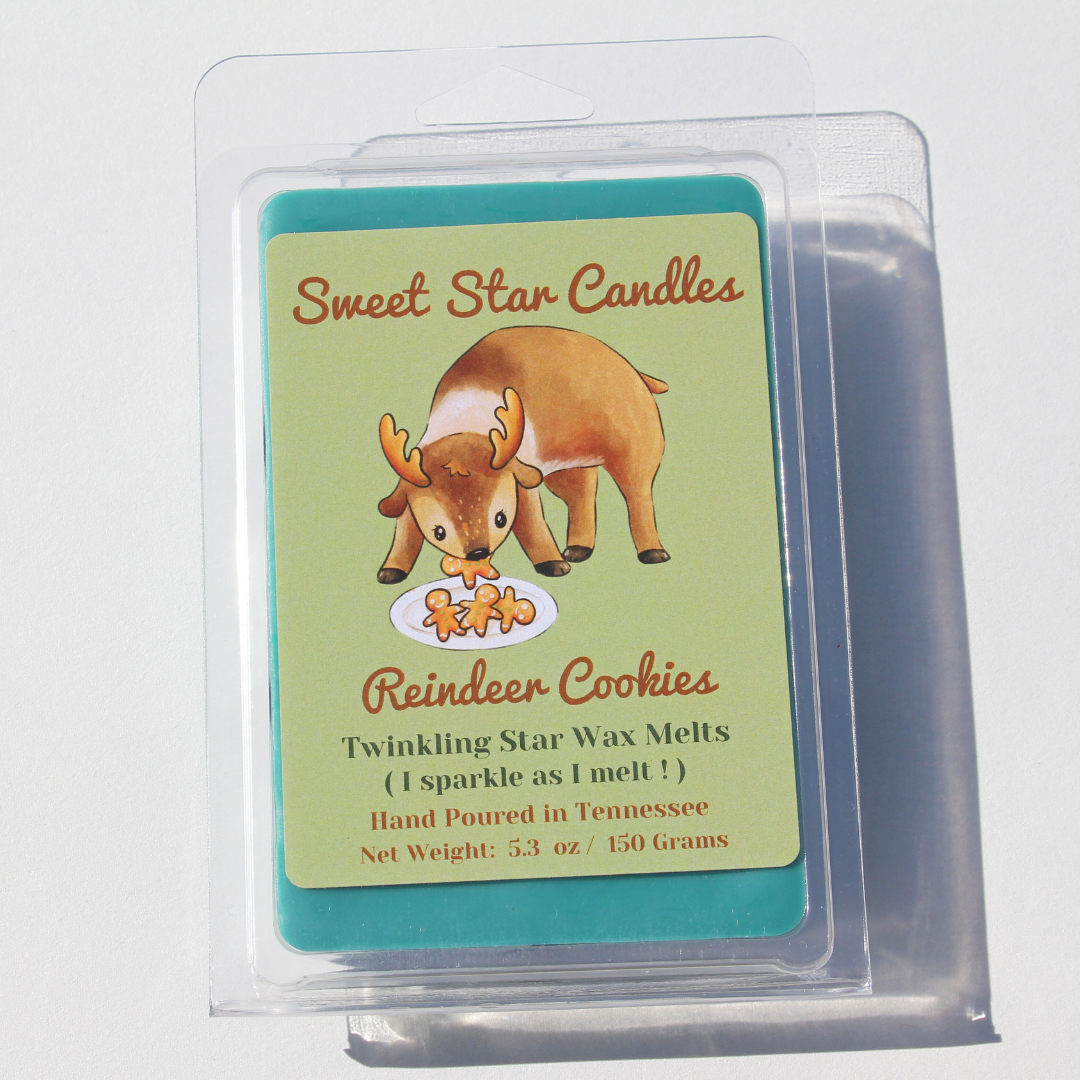 our extra large reindeer cookies soy wax melt sits in a white background features a Christmas green wax and has a light hunter green label the top reads sweet star candles in light brown cursive letters under that is the animal it is a reindeer eating gingerbread cookies from a plate he glances up with a cookie in his mouth under that reads the title reindeer cookies under that reads sparkle as i melt wax melt hand poured in east Tennessee 5.3 ounces or 150 grams
