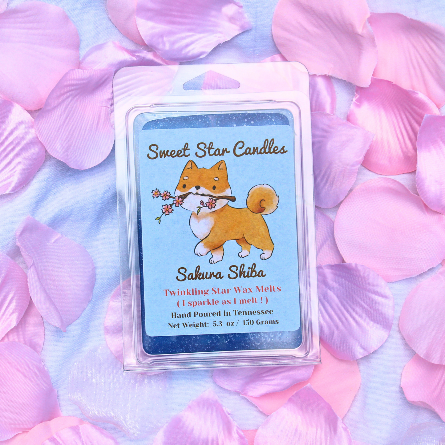 Packaging of Sakura Shiba Twinkling Star Wax Melt with an illustration of a Shiba Inu dog holding a cherry blossom, surrounded by pink petals.