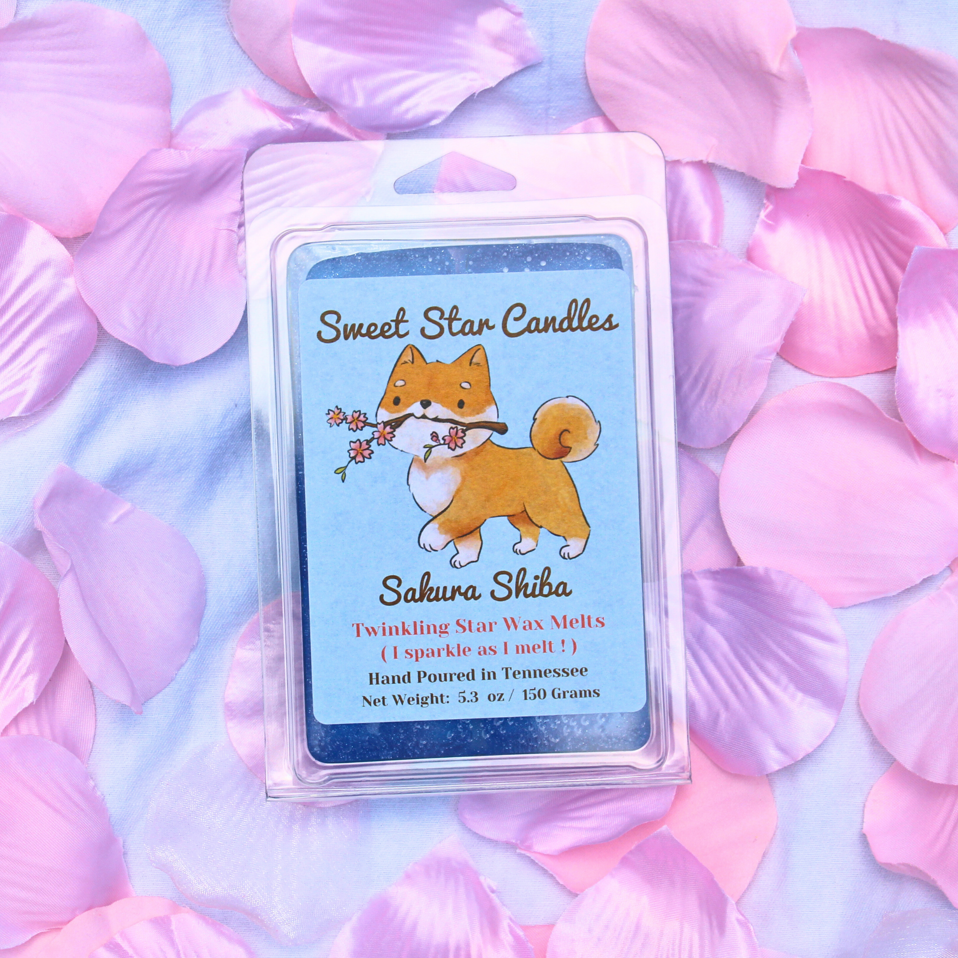 Packaging of Sakura Shiba Twinkling Star Wax Melt with an illustration of a Shiba Inu dog holding a cherry blossom, surrounded by pink petals.