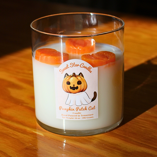 Candle with a 'Pumpkin Patch Cat' label on a wooden surface