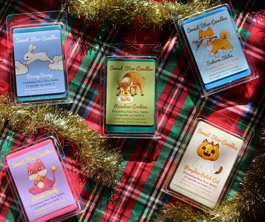 our wax melts sit on a festive background with our breezy bunny wax melt in the top left our cosmic candy wax melt our reindeer cookies wax melt in the center our sakura shiba wax melt in the top right then our pumpkin patch cat wax melt under that