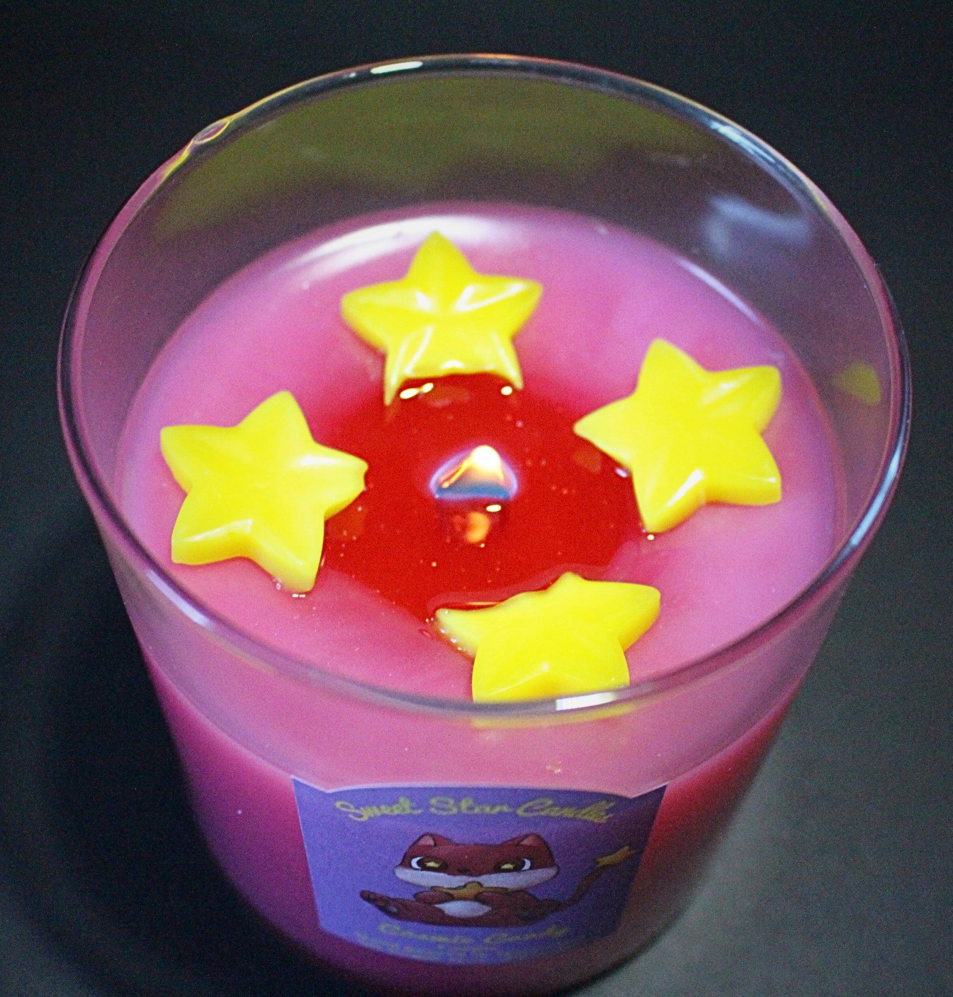 The wax is melting and small sparkles can be seen coming from the melted wax around the flame the wax stars are slowly melting as well